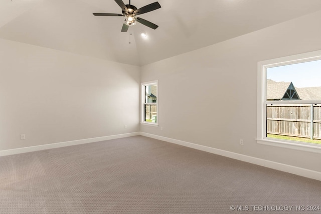 carpeted spare room with ceiling fan, lofted ceiling, and plenty of natural light