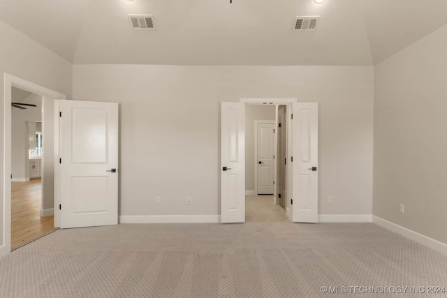 unfurnished bedroom with lofted ceiling and light carpet