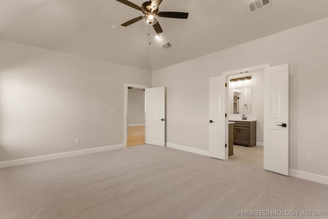 unfurnished bedroom featuring sink, light carpet, high vaulted ceiling, ensuite bathroom, and ceiling fan