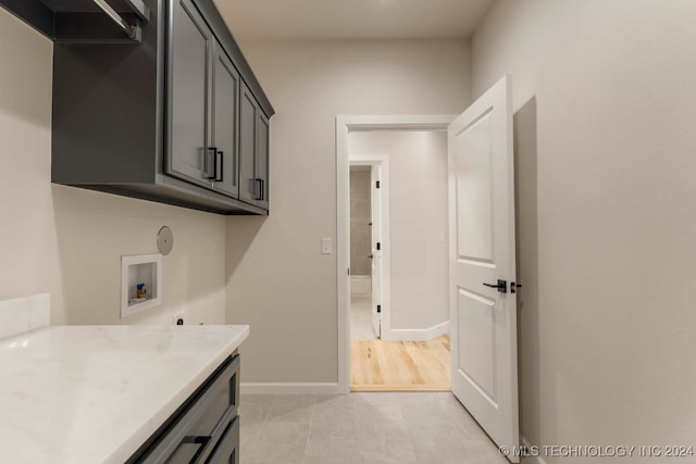 laundry area featuring cabinets, washer hookup, and light tile patterned floors