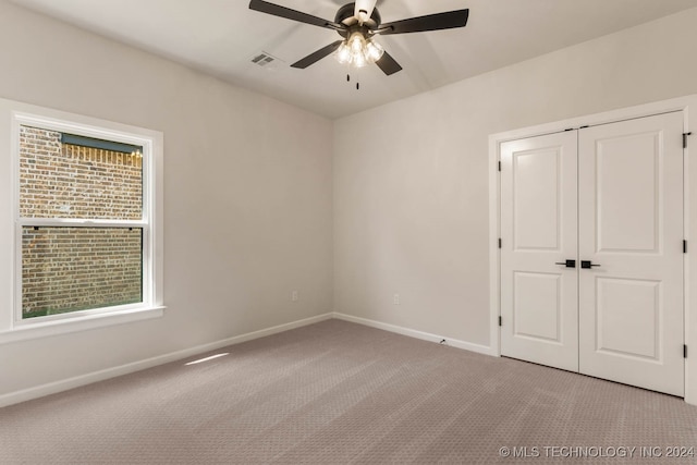 unfurnished bedroom with ceiling fan, light colored carpet, and multiple windows