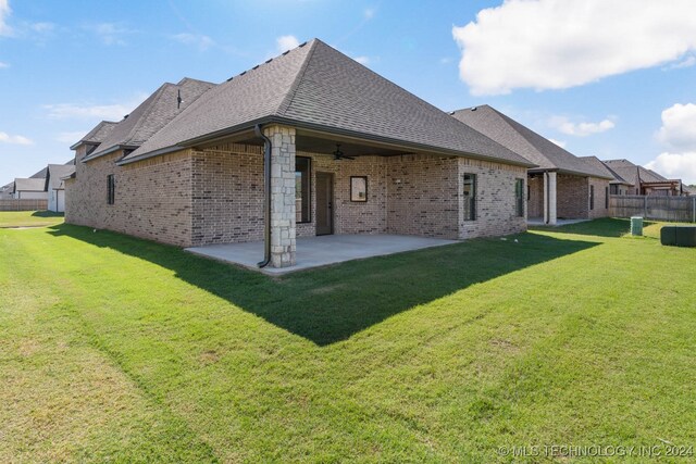 back of house featuring a lawn and a patio