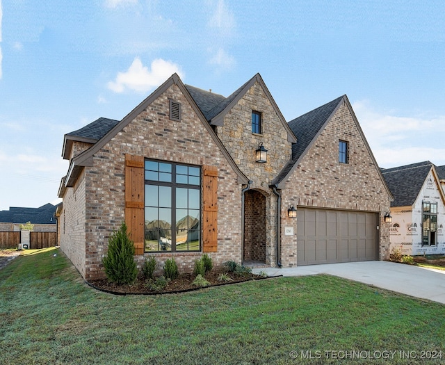 view of front of house featuring a garage and a front lawn