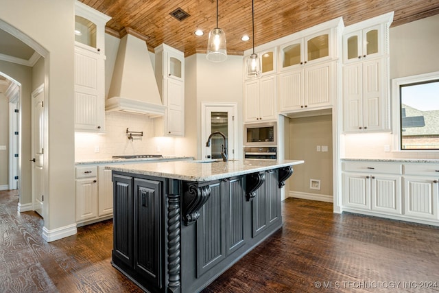 kitchen with wood ceiling, a center island with sink, dark wood-type flooring, white cabinetry, and custom range hood