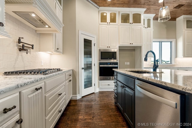 kitchen with white cabinets, pendant lighting, sink, stainless steel appliances, and dark hardwood / wood-style flooring