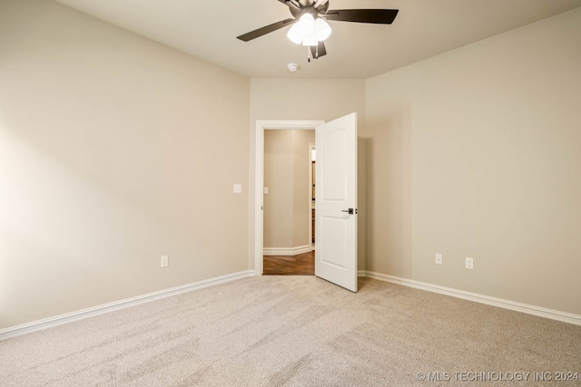 carpeted spare room with ceiling fan