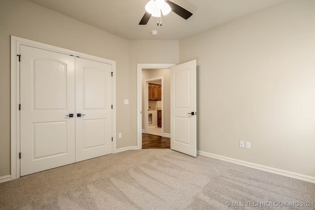 unfurnished bedroom featuring carpet, ceiling fan, and a closet