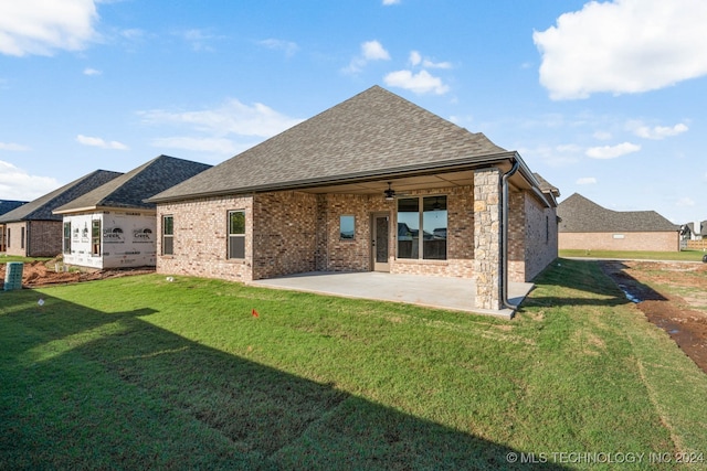 rear view of property with ceiling fan, a lawn, and a patio area