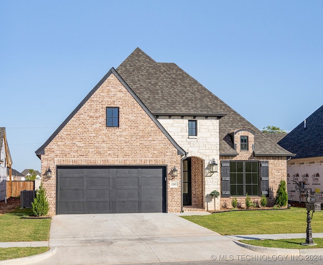 view of front of home featuring cooling unit, a front lawn, and a garage