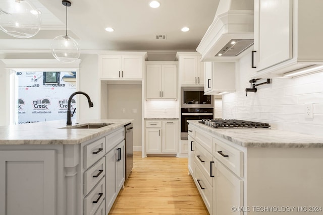 kitchen with white cabinetry, sink, and custom exhaust hood