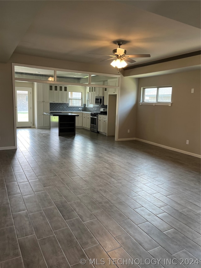 unfurnished living room featuring sink and ceiling fan