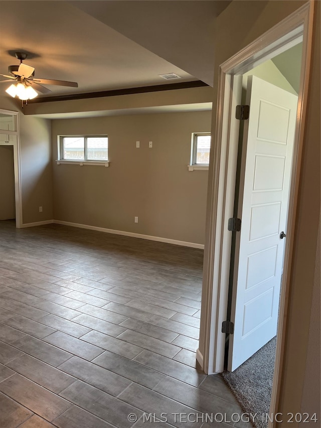 empty room featuring ceiling fan and a tray ceiling