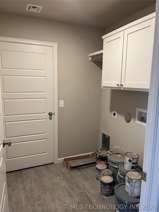 washroom with hookup for an electric dryer, light hardwood / wood-style floors, cabinets, and washer hookup