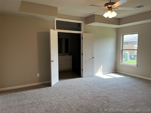 unfurnished bedroom with ceiling fan and dark carpet