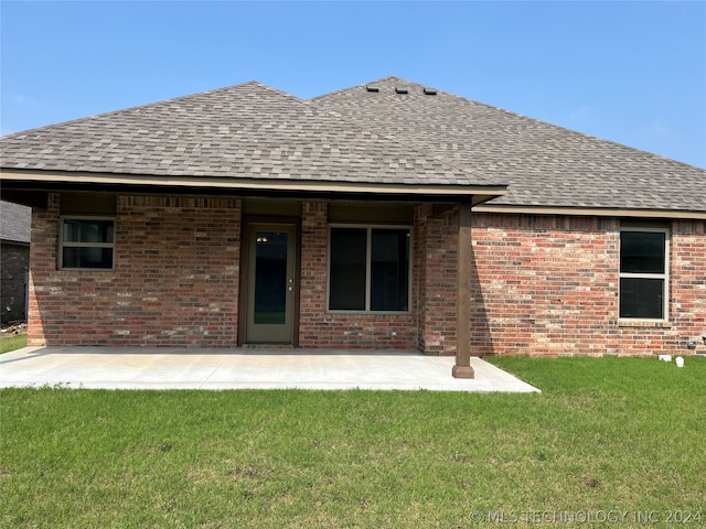 back of property featuring a patio area and a yard