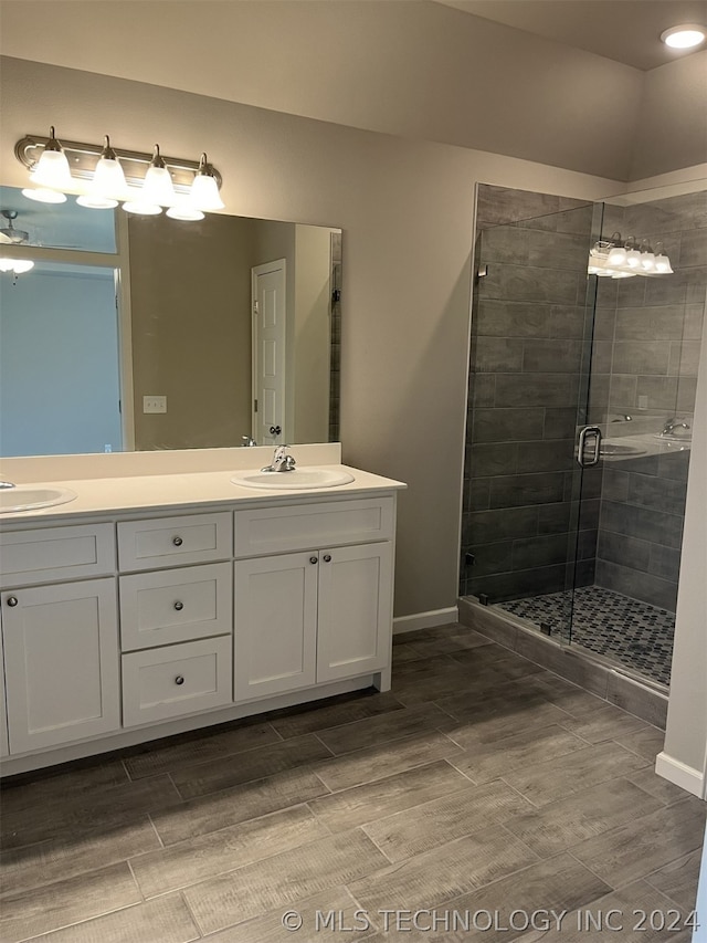 bathroom with an enclosed shower and dual vanity