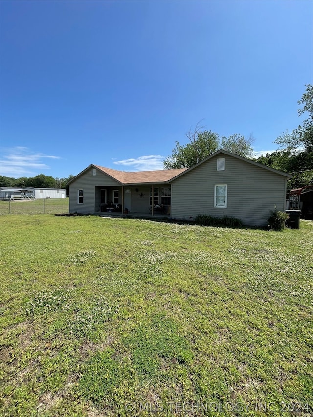 back of property featuring a lawn