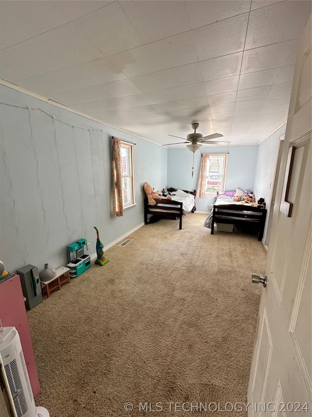 bedroom featuring multiple windows, carpet, and ceiling fan