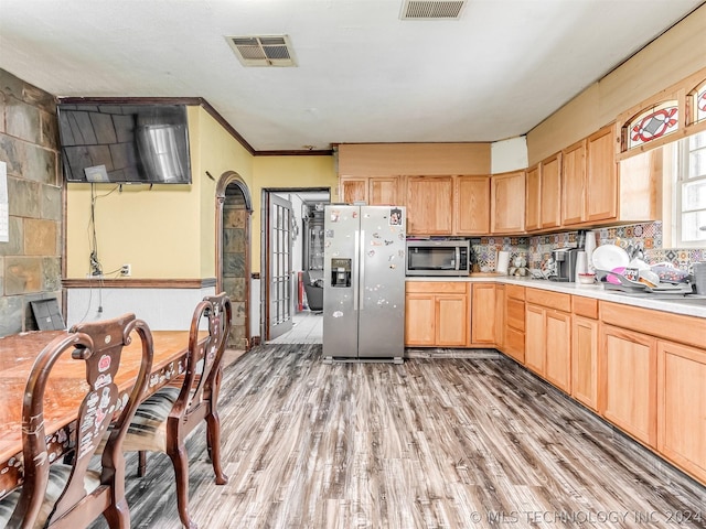 kitchen featuring appliances with stainless steel finishes, wood-type flooring, and light brown cabinets