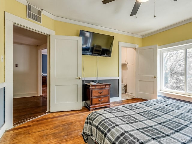 bedroom featuring light hardwood / wood-style flooring, ceiling fan, ensuite bathroom, and crown molding