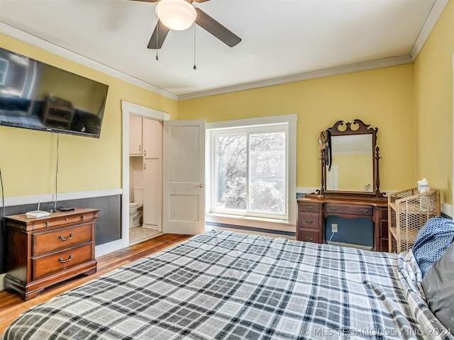 bedroom with crown molding, connected bathroom, ceiling fan, and hardwood / wood-style floors