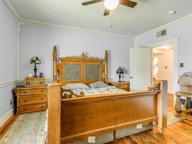 bedroom with light hardwood / wood-style flooring, ceiling fan, and ornamental molding