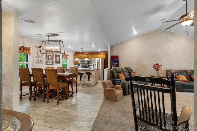 dining space with ceiling fan with notable chandelier and lofted ceiling