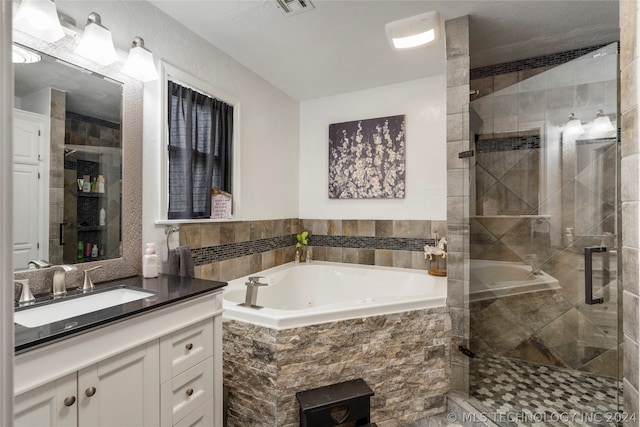 bathroom with vanity and independent shower and bath