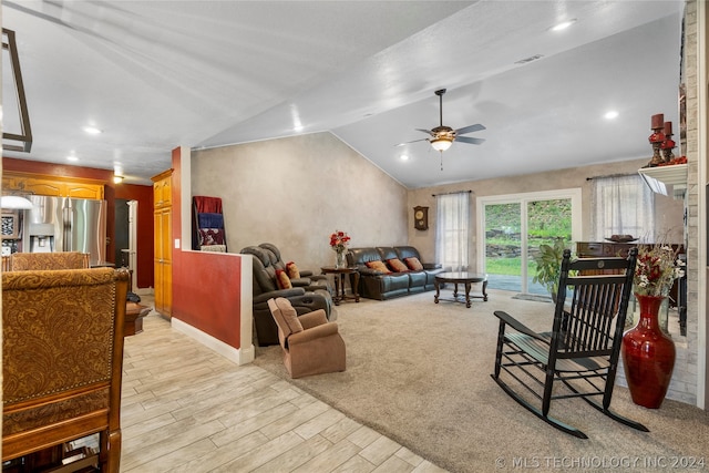 living room featuring light hardwood / wood-style flooring, vaulted ceiling, and ceiling fan