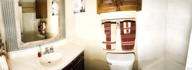 bathroom with vanity, toilet, and tiled shower