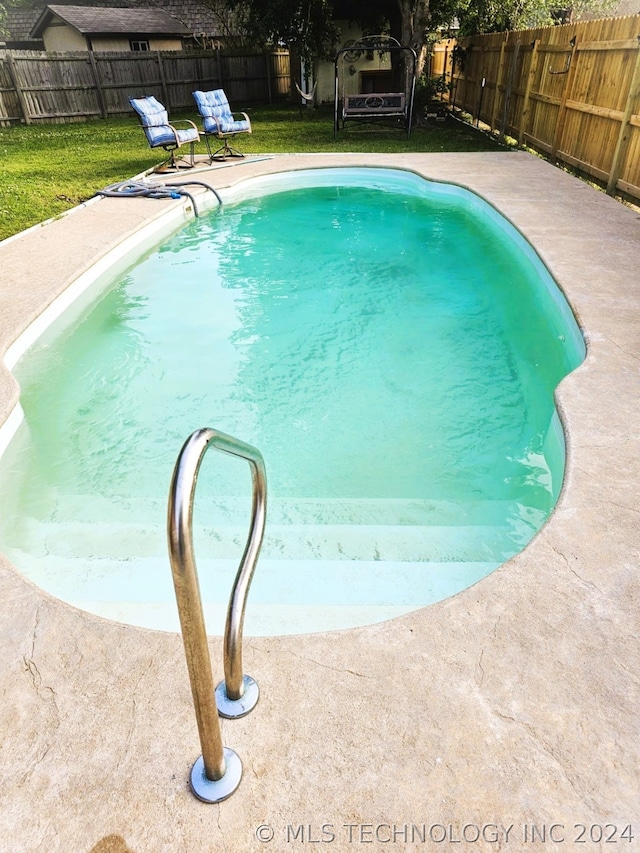 view of pool featuring a lawn