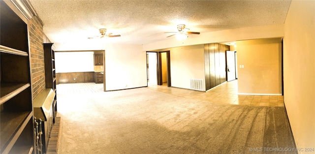 carpeted spare room featuring a textured ceiling and ceiling fan