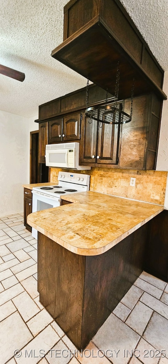 kitchen with wood counters, white appliances, kitchen peninsula, dark brown cabinets, and a textured ceiling