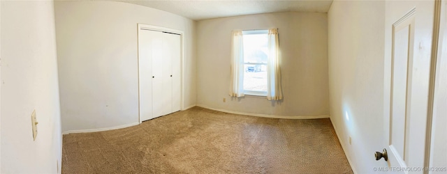 unfurnished bedroom featuring light carpet and a closet