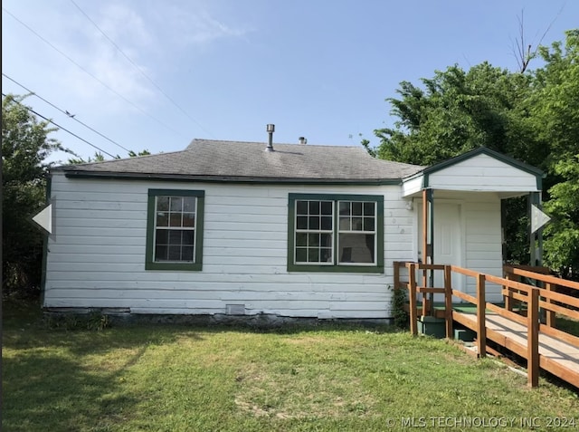 back of property with crawl space, a shingled roof, and a yard