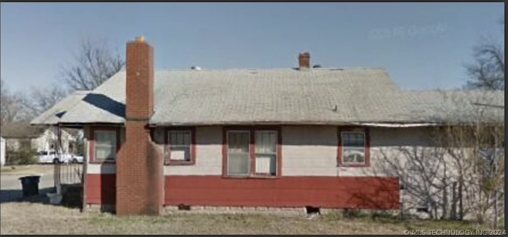 rear view of house featuring a chimney