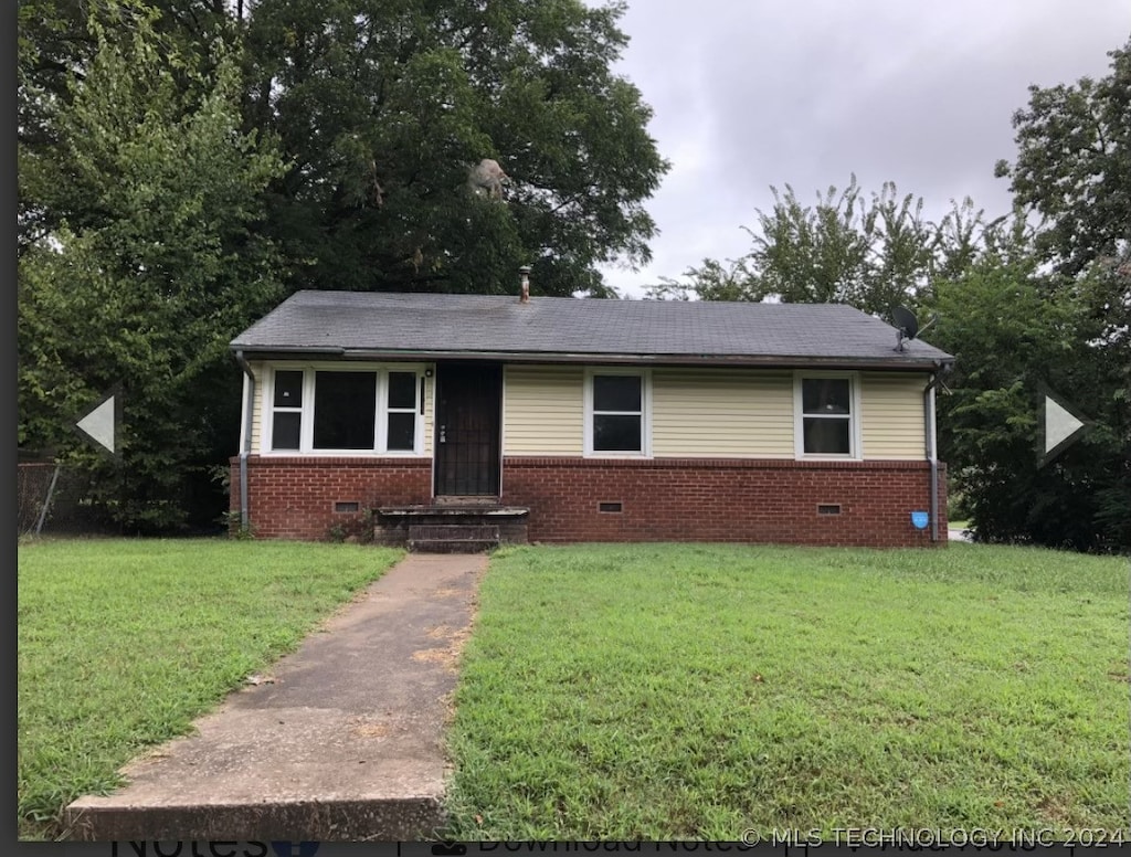 view of front of property featuring a shingled roof, crawl space, brick siding, and a front lawn