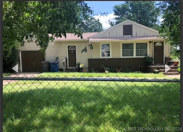 view of front of house with a garage, fence, and a front lawn