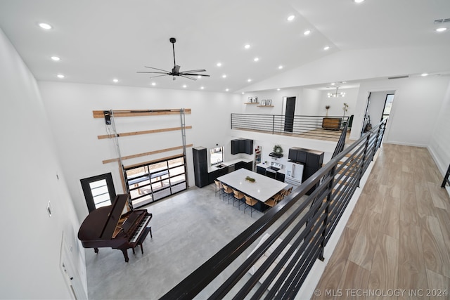 living room with a wealth of natural light, light hardwood / wood-style flooring, ceiling fan, and lofted ceiling