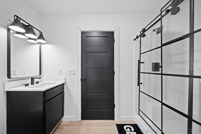 bathroom featuring walk in shower, hardwood / wood-style floors, and vanity