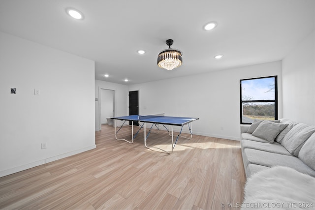 playroom featuring light hardwood / wood-style floors and a notable chandelier