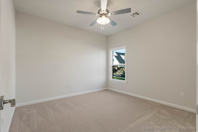 spare room with ceiling fan and light colored carpet