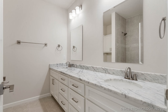 bathroom featuring a tile shower, tile patterned floors, and vanity