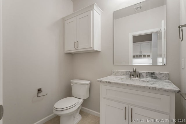 bathroom featuring tile patterned flooring, vanity, and toilet