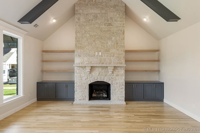 unfurnished living room featuring beamed ceiling, a fireplace, light hardwood / wood-style floors, and high vaulted ceiling