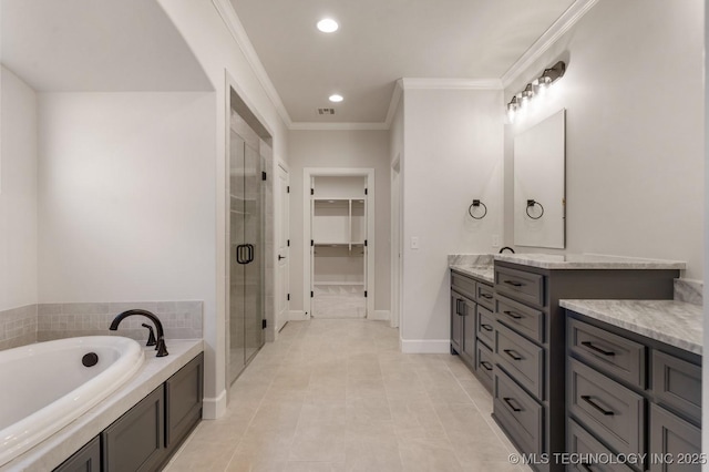 full bathroom with a walk in closet, a garden tub, ornamental molding, vanity, and a shower stall