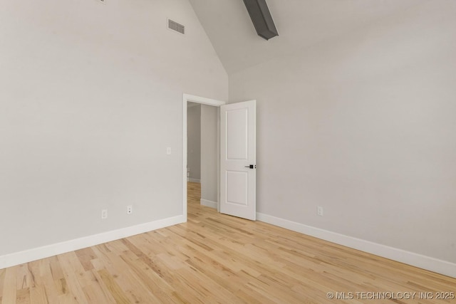 unfurnished room featuring light wood-type flooring, high vaulted ceiling, baseboards, and visible vents