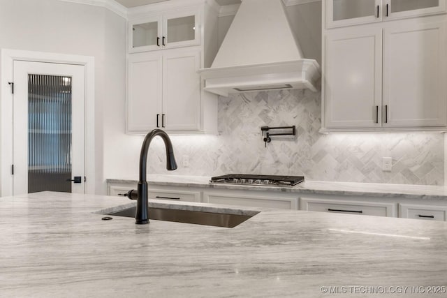 kitchen featuring glass insert cabinets, premium range hood, and white cabinetry