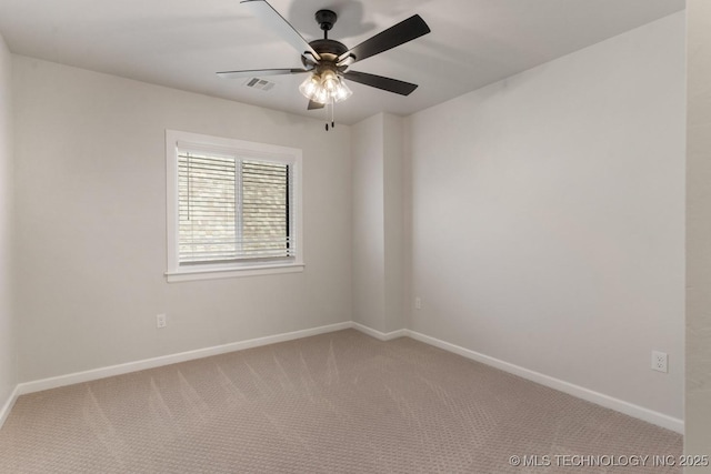 carpeted spare room featuring ceiling fan, visible vents, and baseboards