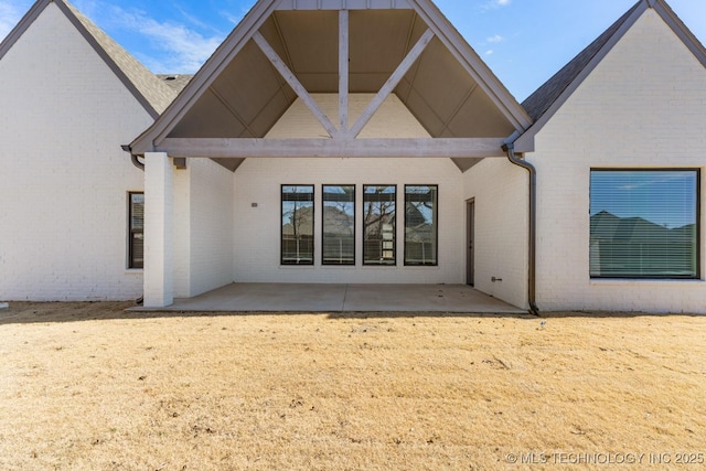 back of property with a patio area and brick siding